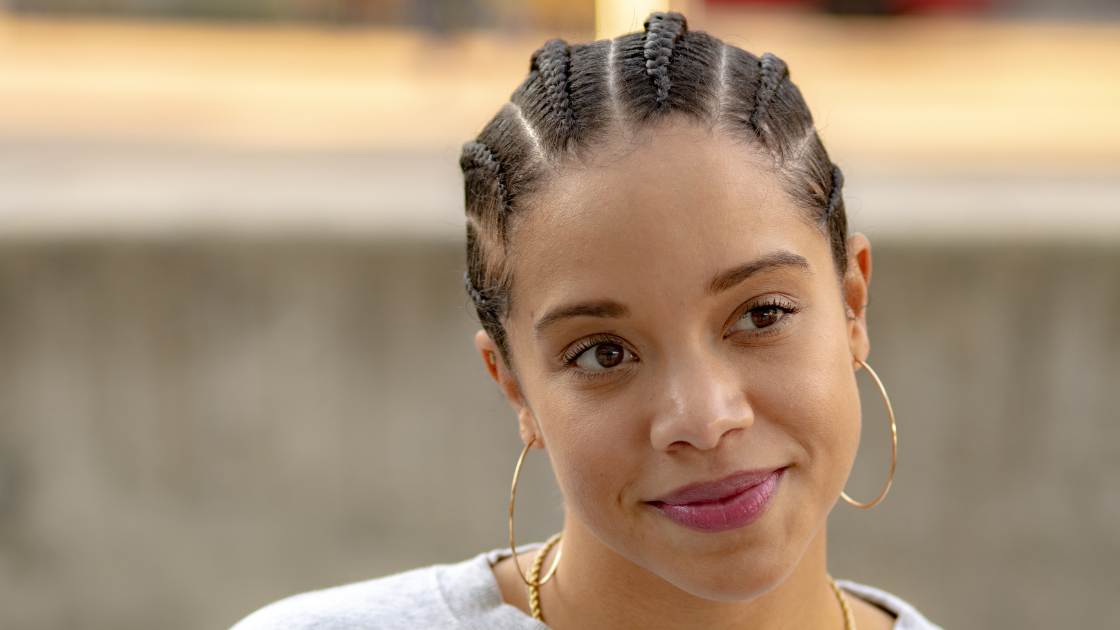 Hübsche Frau mit Goldene Ohrringe mit Cornrows