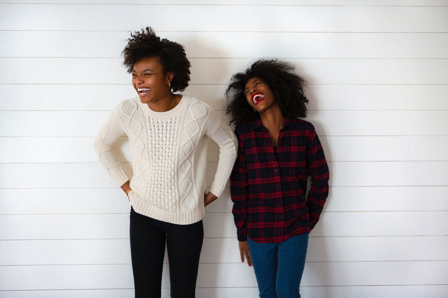 Zwei entspannte und lachende Frauen mit Afrohaaren