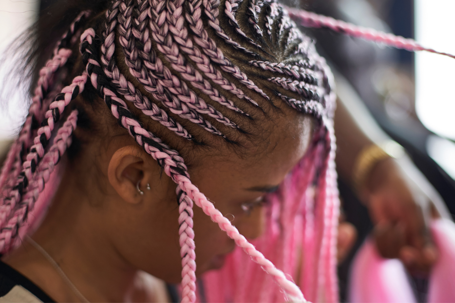 Frau mit pinken geflochtenen Afrohaaren